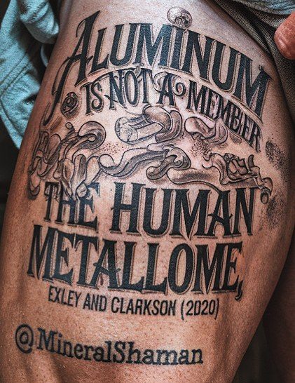 A tattoo on a thigh in black lettering: 